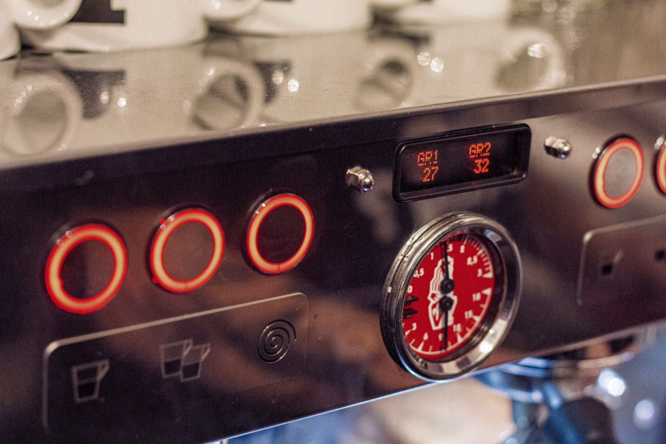 Nahaufnahme einer Espressomaschine mit Manometer und digitaler Anzeige.