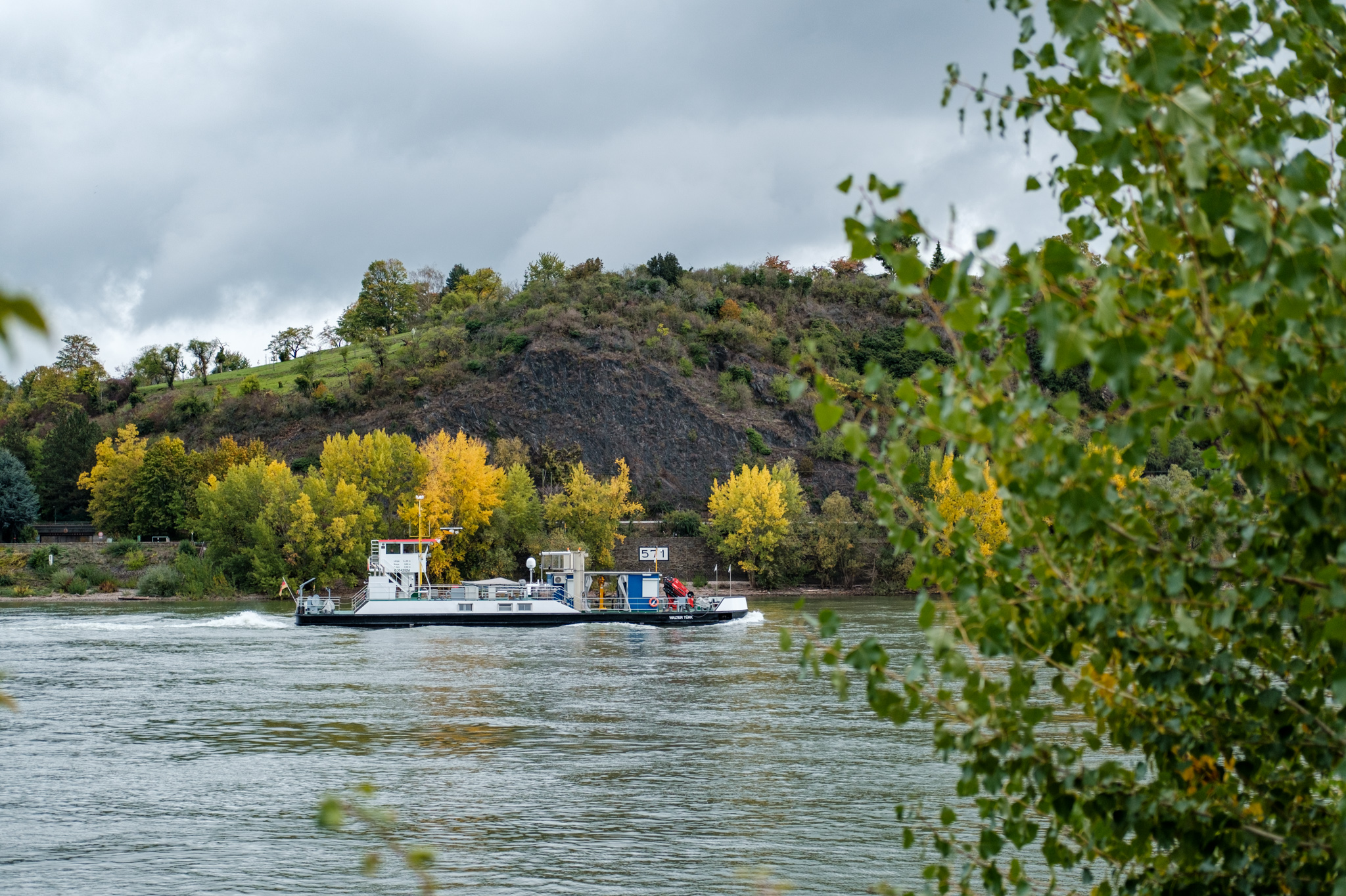 Ein Messschiff auf dem Rhein, im Hintergrund sind herbstlich gelb gefärbte Bäume.