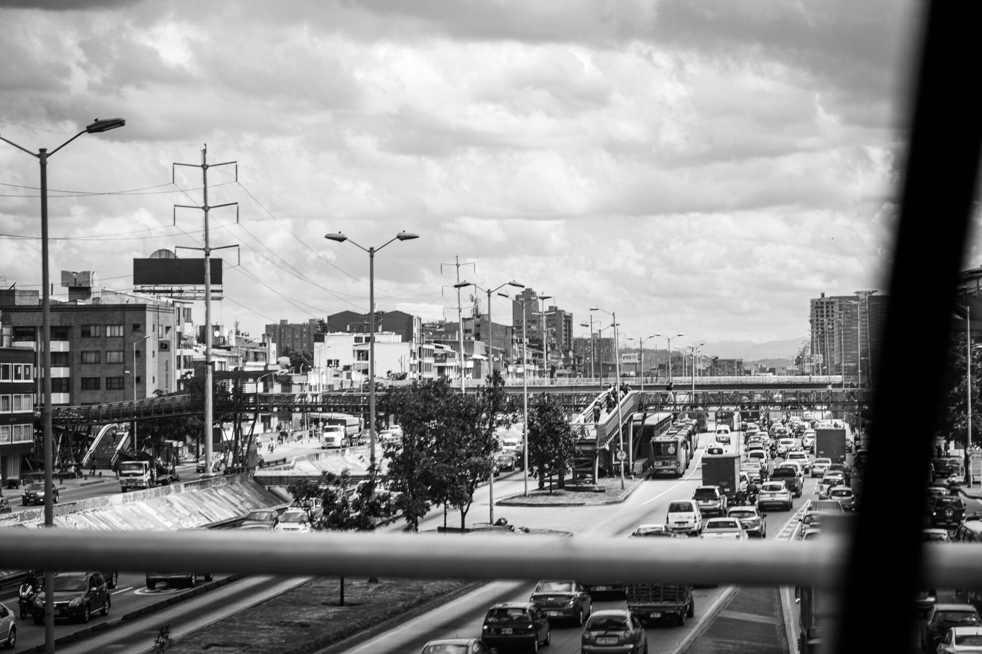 Blick aus einem Auto von einer Brücke auf eine verstopfte mehrspurige Straße in Bogota.