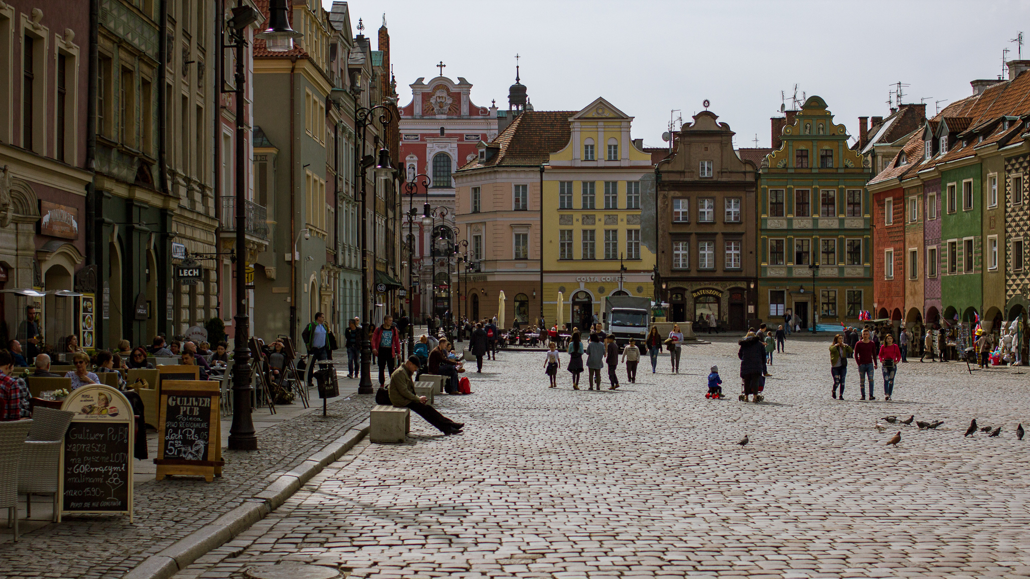 Blick auf den gepflasterten Marktplatz von Posen, rechts und links gesäumt von bunten, historischen Gebäuden.