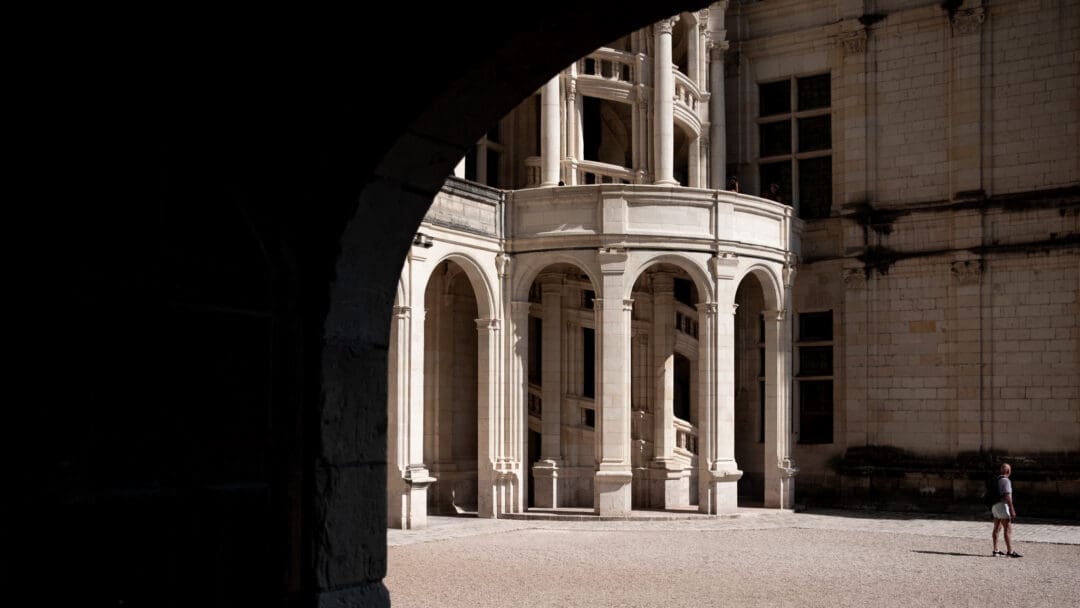 Äußere Wendeltreppe, eingefasst in Säulen, am Schloss Chambord, angestrahlt von Sonnenlicht
